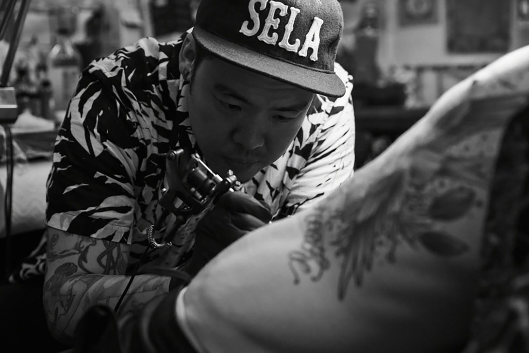 Dr Woo (Brian Woo) while tattooing, photographed by Andrew Arthur, via Hyperbeast