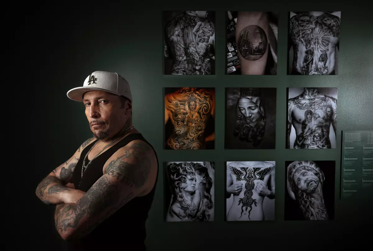 Freddy Negrete, photographed next to part of a Natural History Museum exhibit on the black-and-gray style that he helped to popularize in L.A. (Mel Melcon / Los Angeles Times)