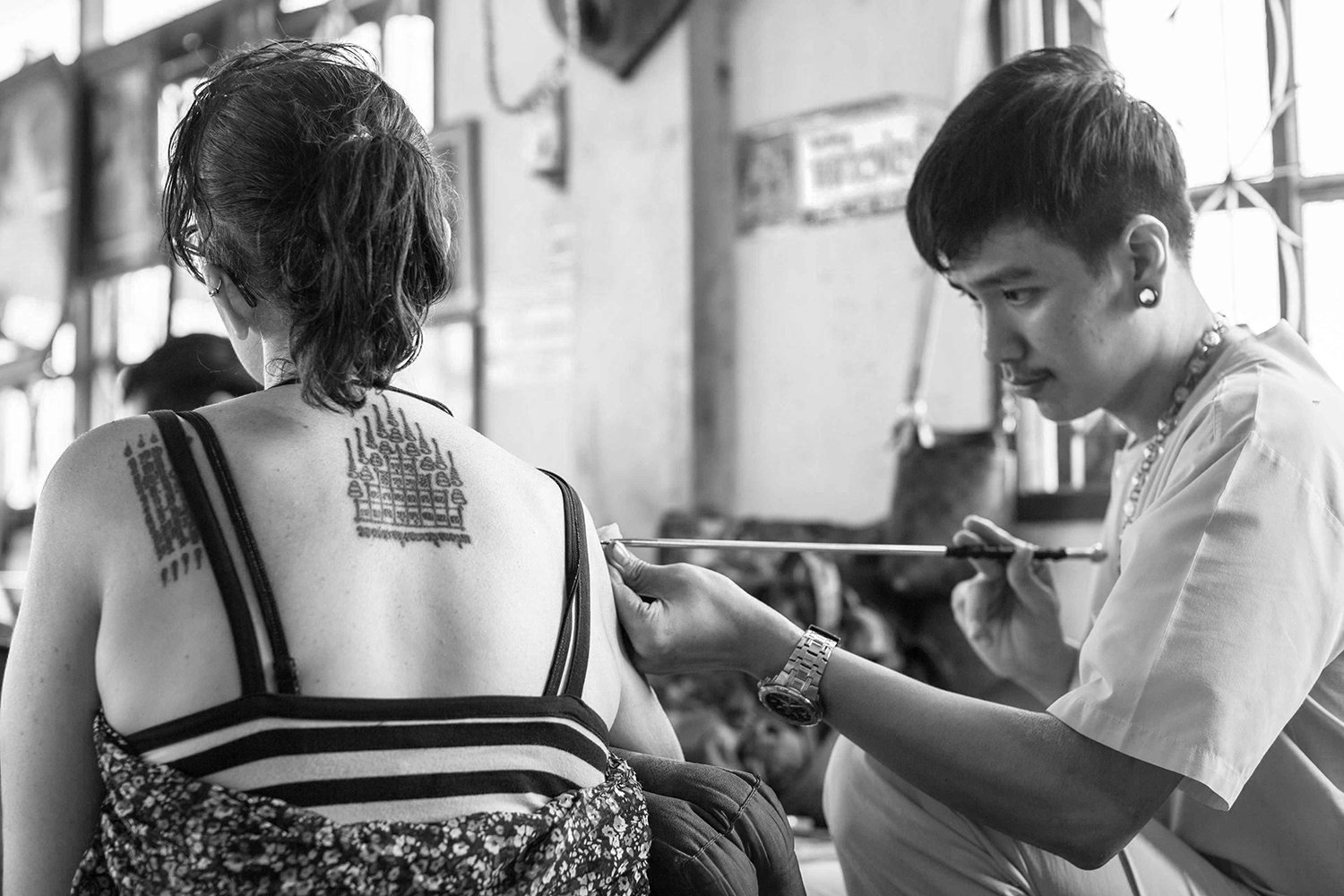 Sak Yant traditional tattoo session with khem sak (tool) via Shutterstock