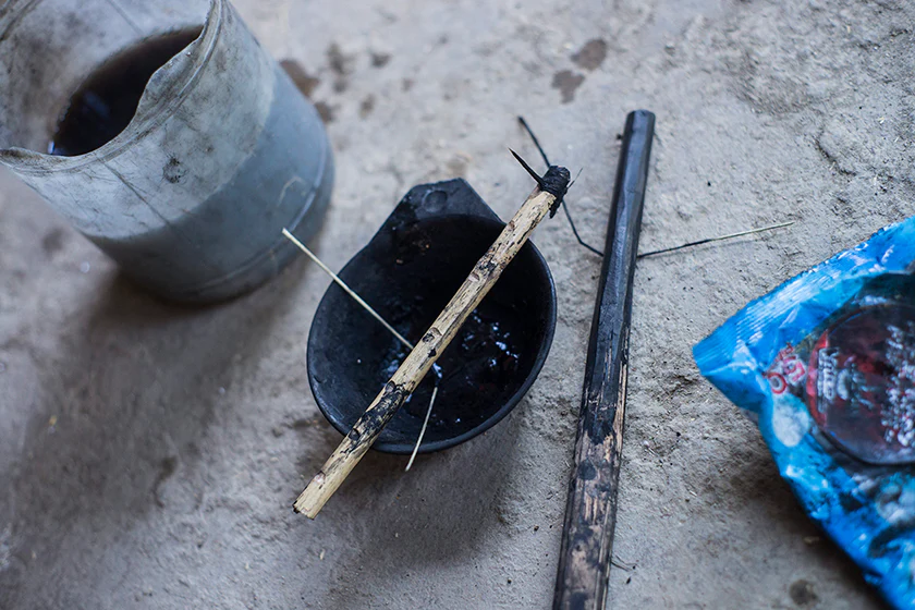 Tattooing stick with a pomelo thorn attached, a ceramic bowl for ink, and a plastic washpot, photographed by Fred Wissink, The New Traditional
