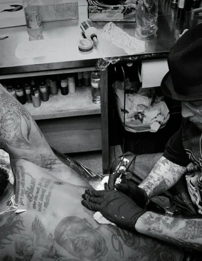 Photo of Freddy Negrete at work, tattooing man's chest