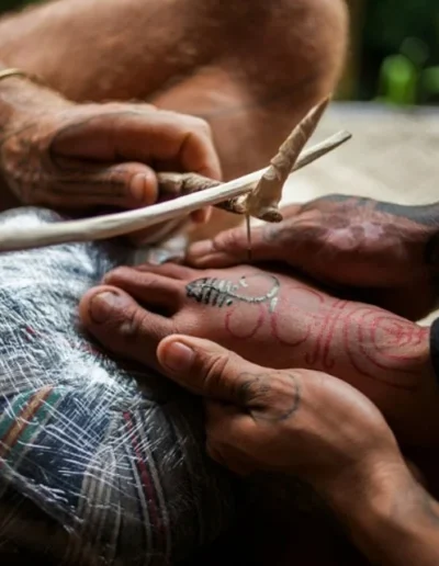 A tattoo artist uses the traditional 'hand tapping' method by AFP via Daily Mail