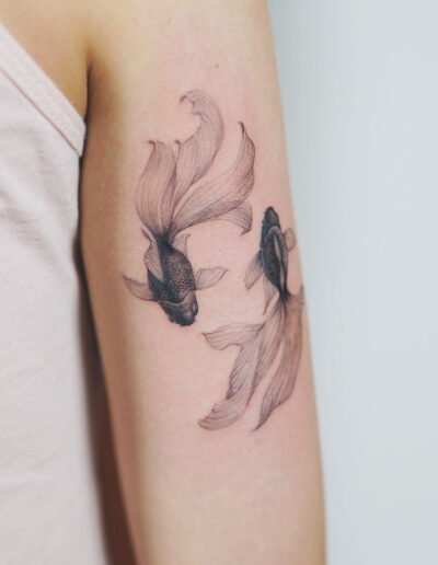 Black goldfish tattoo by Nando @nandotattooer