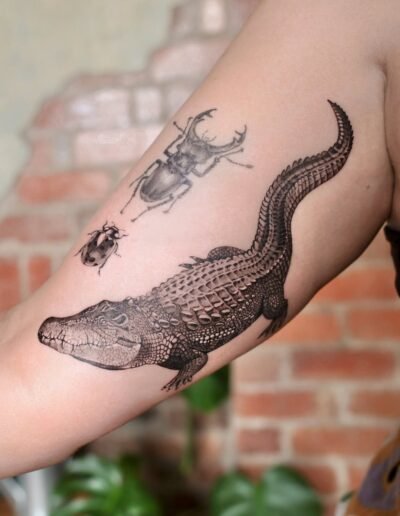 Crocodile and ladybug tattoo by SAV @savv.ink