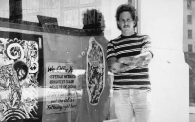 Don Ed Hardy in front of his SD shop on Columbia St, just off of Broadway. The reflection in the first photo is the Army-Navy YMCA building.