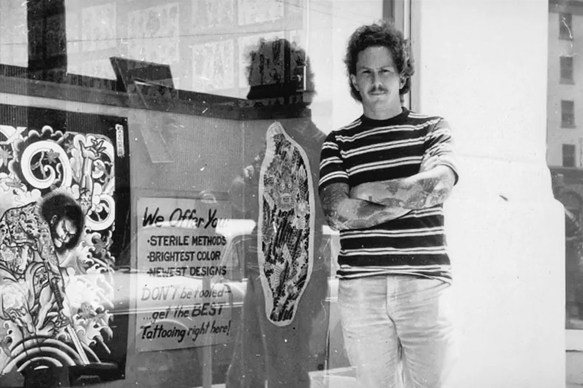 Don Ed Hardy in front of his SD shop on Columbia St, just off of Broadway. The reflection in the first photo is the Army-Navy YMCA building.