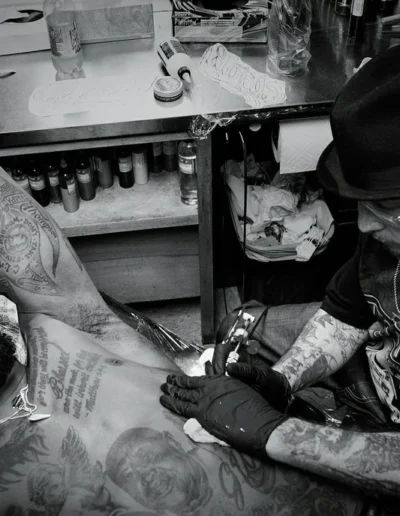 Photo of Freddy Negrete at work, tattooing man's chest