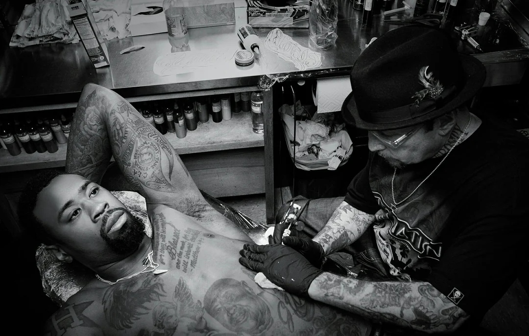 Photo of Freddy Negrete at work, tattooing man's chest